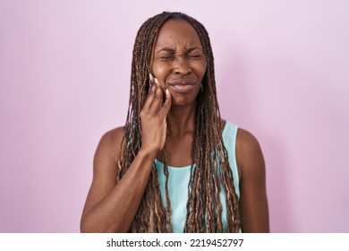 African American Woman Standing Over Pink Background Touching Mouth With Hand With Painful Expression Because Of Toothache Or Dental Illness On Teeth. Dentist 