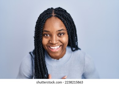 African american woman standing over blue background smiling and laughing hard out loud because funny crazy joke with hands on body.  - Powered by Shutterstock