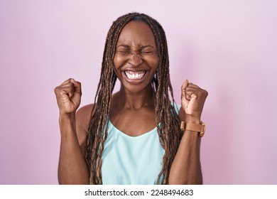 African american woman standing over pink background excited for success with arms raised and eyes closed celebrating victory smiling. winner concept.  - Shutterstock ID 2248494683