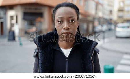 African american woman standing with serious expression at street