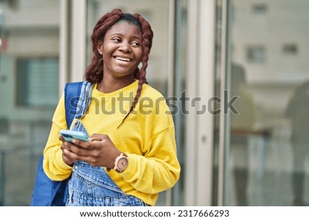 African american woman student smiling confident using smartphone at university