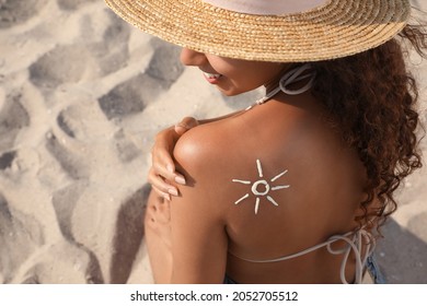 African American Woman With Sun Protection Cream On Shoulder At Sandy Beach