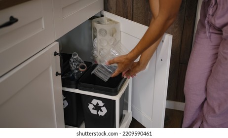 African American Woman Takes Vegetables Out Of Mesh Bag. Housewife Takes Care Of Ecology Throwing Plastic Container Into Trash Bin