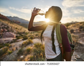 African American Woman Taking A Break To Drink From Water Bottle While Hiking At Red Rock Canyon Nevada