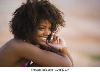 African American Woman Talking On Phone On Seashore