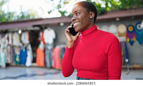 African american woman talking on smartphone smiling at street market - Shutterstock ID 2286061811