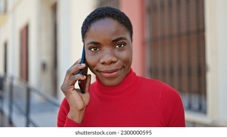 African american woman talking on smartphone smiling at street - Shutterstock ID 2300000595