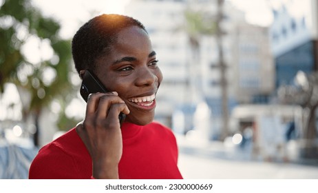 African american woman talking on smartphone smiling at street - Shutterstock ID 2300000669