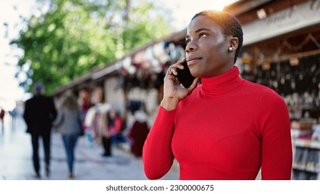 African american woman talking on smartphone with serious expression at street market - Shutterstock ID 2300000675