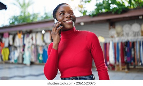 African american woman talking on smartphone smiling at street market - Shutterstock ID 2361520075