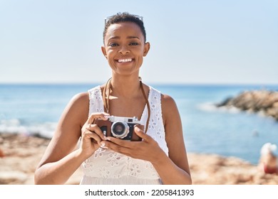 African American Woman Tourist Using Vintage Camera At Seaside