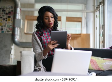 African American Woman Typing On Her Tablet.