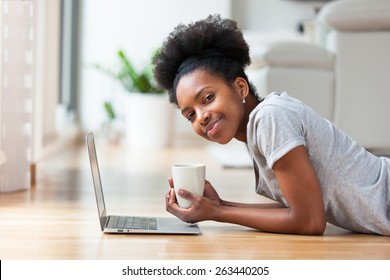 African American Woman Using A Laptop In Her Living Room - Black People