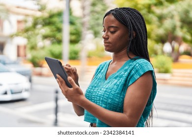 African american woman using touchpad with serious expression at park - Powered by Shutterstock