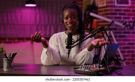 African American Woman Vlogger Talking To Audience While Recording Podcast Using Audio Mixer And Microphone. Famous Influencer Creating Content For Online Social Media Page From Podcasting Studio.