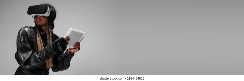 African american woman in vr headset using digital tablet isolated on grey, banner