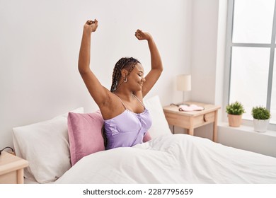 African american woman waking up stretching arms at bedroom - Powered by Shutterstock