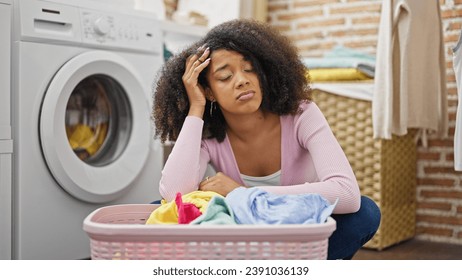 African american woman washing clothes looking upset at laundry room - Powered by Shutterstock