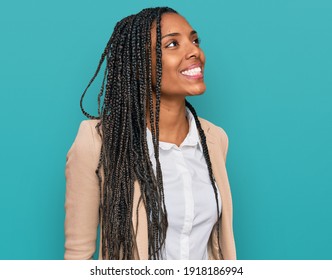 African american woman wearing business jacket looking away to side with smile on face, natural expression. laughing confident. 