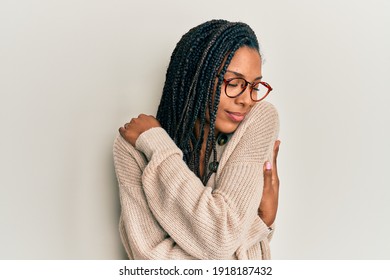 African american woman wearing casual clothes and glasses hugging oneself happy and positive, smiling confident. self love and self care 
