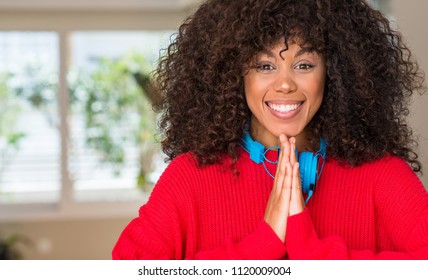 African American Woman Wearing Headphones Praying With Hands Together Asking For Forgiveness Smiling Confident.