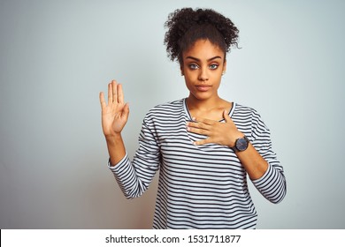 African American Woman Wearing Navy Striped T-shirt Standing Over Isolated White Background Swearing With Hand On Chest And Open Palm, Making A Loyalty Promise Oath