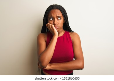 African american woman wearing red casual t-shirt standing over isolated white background looking stressed and nervous with hands on mouth biting nails. Anxiety problem. - Shutterstock ID 1531860653