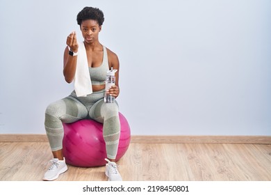 African American Woman Wearing Sportswear Sitting On Pilates Ball Doing Italian Gesture With Hand And Fingers Confident Expression 