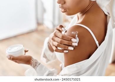 African American woman in white dress holding a jar of cream in a modern bathroom. - Powered by Shutterstock