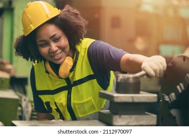 African American woman worker happy smiling working with metal machine in heavy industry factory - Shutterstock ID 2112970097