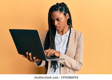 African American Woman Working Using Computer Laptop Angry And Mad Screaming Frustrated And Furious, Shouting With Anger. Rage And Aggressive Concept. 