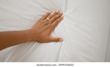 African american woman's hand with rings on white bedsheets - Powered by Shutterstock