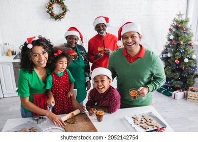 African American Women Rolling Out Dough While Preparing Christmas Cookies With Family