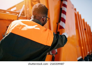 African American Worker Of The City Utility Company On His Job. Garbage Collector.