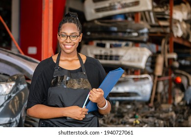 African American Worker Woman Wear Spectacles Crossed Arms Holding Clipboard Standing In Factory Auto Parts. Female Employee Business Warehouse Motor Vehicle.