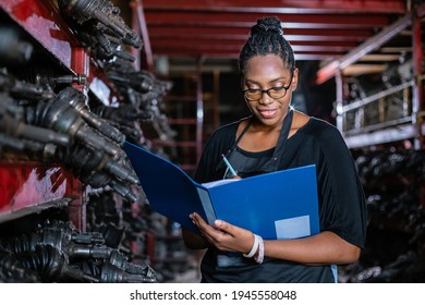 African American Worker Woman Wear Spectacles Crossed Arms Holding Clipboard Standing In Factory Auto Parts. Female Employee Business Warehouse Motor Vehicle.