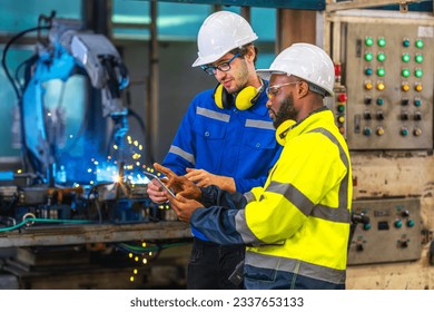 African american worker working in old united state factory in robot auto welding machine section and welding for assembly matal part, America - Powered by Shutterstock