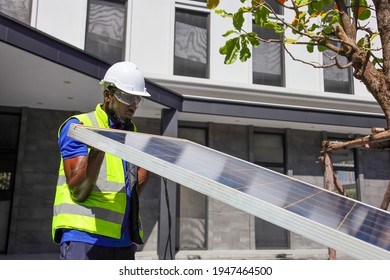 African American Worker Working On Installing Solar Panel On The Rooftop Of The House For Renewable Energy And Environmental Friendly Outcome Concept