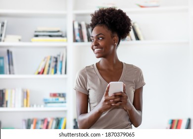 African American Young Adult Man Shopping Online With Mobile Phone Indoors At Home