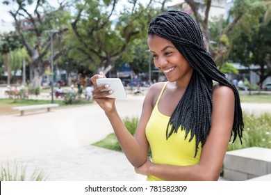 African American Young Adult Woman Watching Tv With Phone