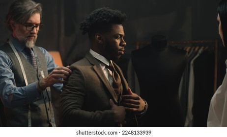 African American young businessman on suit fitting in stylish luxury designer atelier or tailoring studio. Tailored wedding or business suit. Concept of fashion, handmade, hand craft and couturier. - Powered by Shutterstock