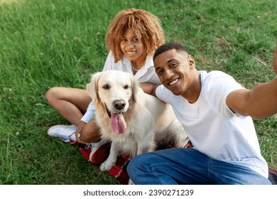 african american young couple sit in park together with dog and take selfie, man and woman with golden retriever communicate via video call in nature, happy family with pet - Powered by Shutterstock