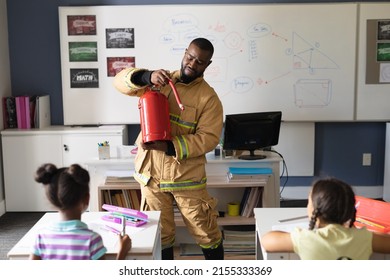 African american young male teacher in uniform showing fire extinguisher to multiracial students. unaltered, education, firefighter, safety, protection, teaching and school concept. - Powered by Shutterstock