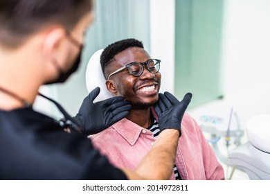 African American Young Man Having A Visit At The Dentist's. He Is Sitting On Chair At Dentist Office In Dental Clinic.