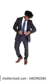 An African American Young Man Standing In A Suit And White Shirt And
Tie Looking At His Watch In The Studio, Isolated For White Background
