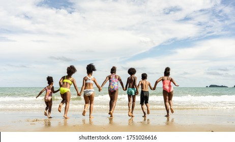 African American,group Of Children Kids Brother Or Sister Hold Hands And Run Together To Play In The Sea On Summer Vacation With Family Or School Friend After Unlocking Down From COVID 19.