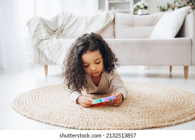 African Americgame, Pop It, Silicone, Toy, African, Child, Black, Antistress, Autism, Handsan Girl On The Floor At Home Playing With A Pop Toy, Pressing Buttons, Relieving Stress