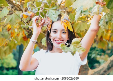 African arab young girl between yellow leaves smiling and saluting to camera. Natural isolated. Social network day at nature concept. Beauty portrait. Copy space for text and adds. Health.