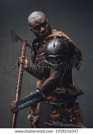 African barbarian dressed in protective armor and deerskin wielding an axe
