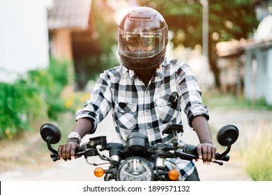 African biker in the helmet and glasses driving a motorcycle rides - Shutterstock ID 1899571132